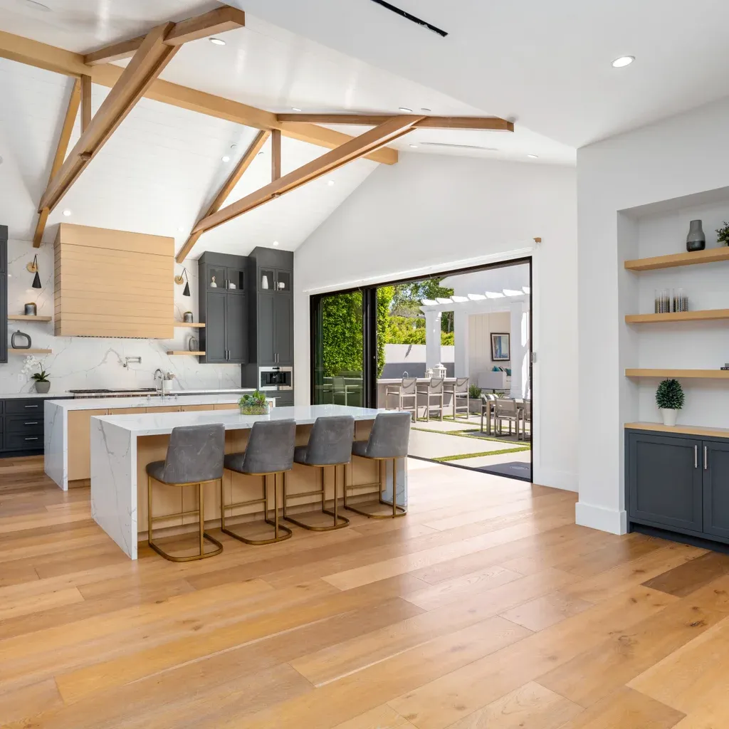 A modern kitchen featuring wooden beams, a large island, and hardwood flooring in West Palm Beach, Jupiter, FL.