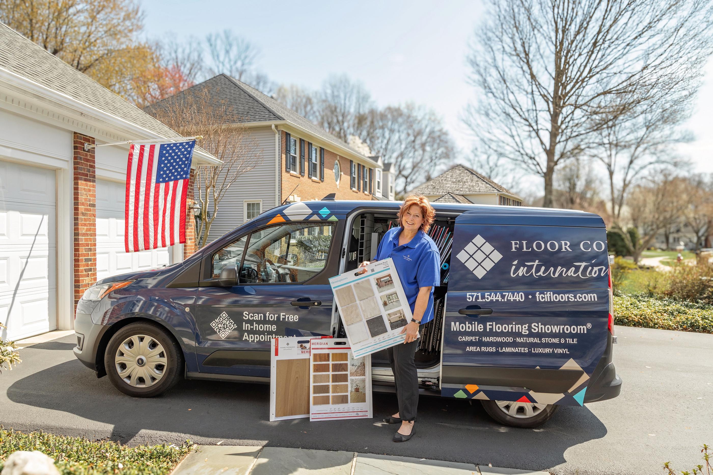 Woman in blue holding flooring samples in front of FCI mobile showroom