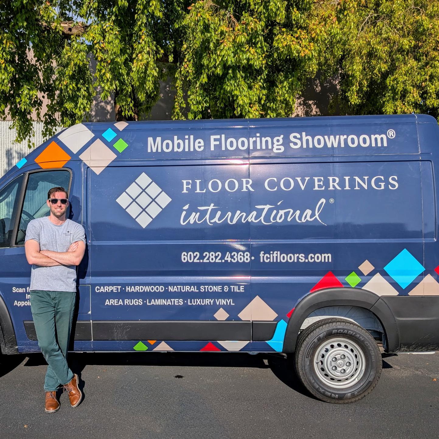 Man crossing his arms leaning against a blue FCI mobile showroom